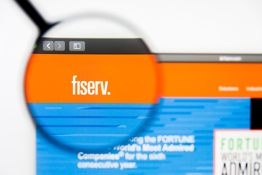 A screenshot of Fiserv's website with a magnifying glass over the name 'fiserv'