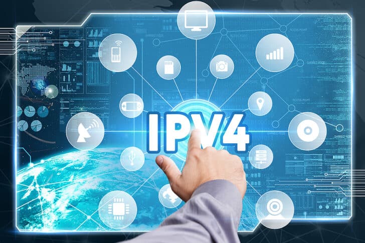 Man pointing to the word IPV4 on a screen that connects to images of monitors, mobile phones, and satellites.