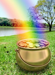 A pot of gold at the end of a rainbow, with a lake and trees in the background