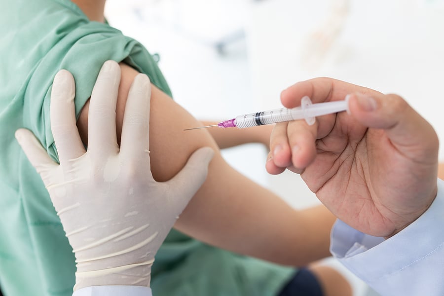 Image of a person getting a vaccine in their right arm.